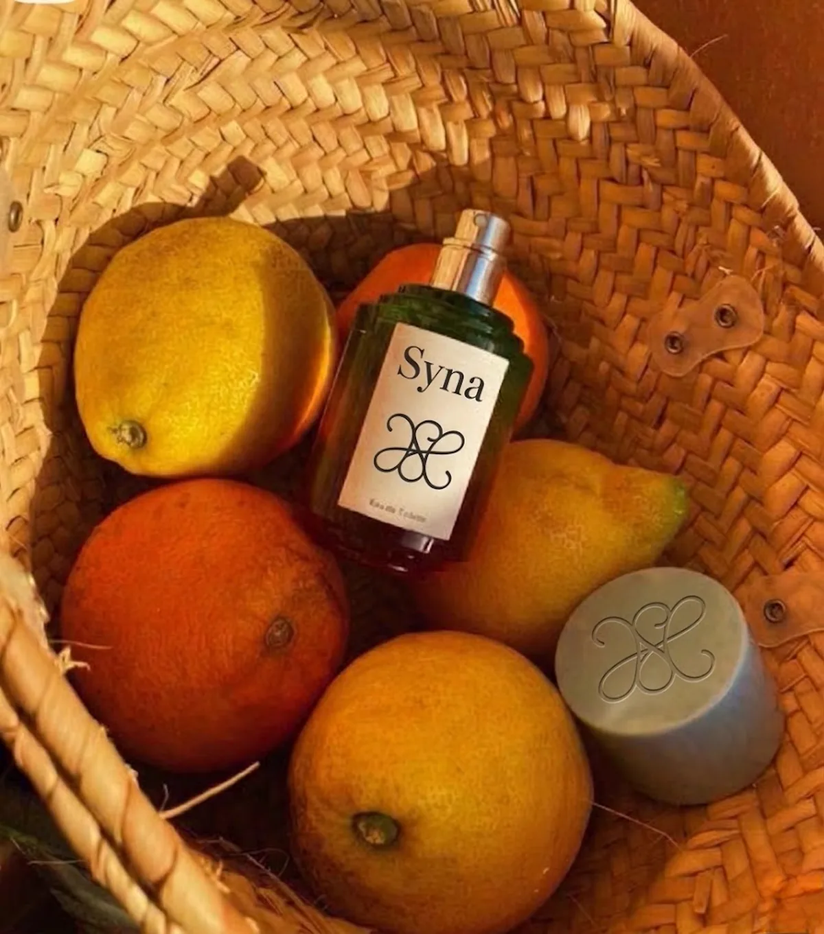 Flacon signe Syna et agrumes dans un univers sensible et solaire