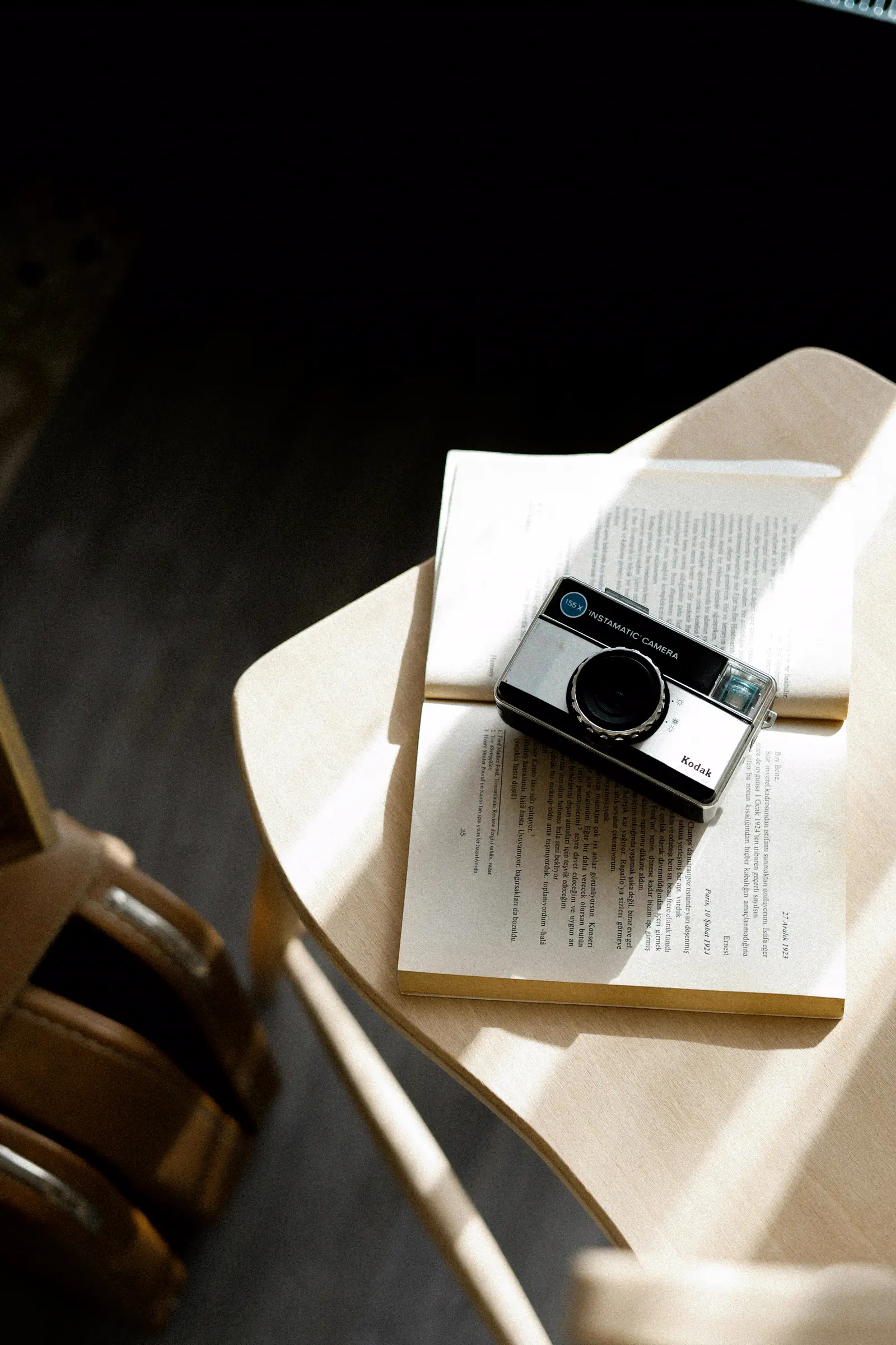 Livre et appareil photo dans une ambiance creative et chaleureuse pour le projet Atelier Lumiere